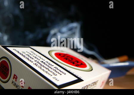 Cigarette box, EU-warning tip cigarettes, filtertip cigarettes, box, cigarette packet, mark, cigarette mark, producer, Lucky Strike, cigarettes-warning tip, warning tip, warning, cigarette label, label, print, refreshing, EU regulation, order, duty to inform, information, customer's information, deterrence, health, health risk, clarification, attention, background, ashtray, smoke, still life, object photography, no property release, Stock Photo