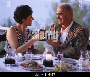 Restaurant, terrace, couple, middle old person, eye contact, wineglasses, kick off, detail, blur summer, leisure time, vacation, lifestyle, happily, together, falls in love, love, affection, tuning, atmospheric, evening light, red wine, wine, drink, alcohol, alcoholic, alcoholic, table, covered Stock Photo