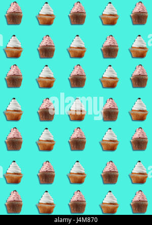 Colorful pattern made of cupcakes on blue background. Stock Photo