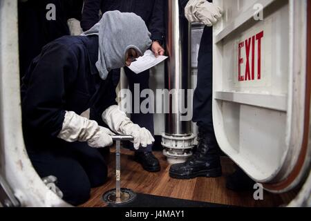 161105-N-NT265-006 PHILIPPINE SEA (Nov. 5, 2016) Petty Officer 3rd Class Arianna Hutcherson, assigned to the forward-deployed Arleigh Burke-class guided-missile destroyer USS McCampbell (DDG 85), closes a valve during a general quarters drill. McCampbell is on patrol in the Philippine Sea with Carrier Strike Group Five (CSG 5) supporting security and stability in the Indo-Asia-Pacific region. (U.S. Navy photo by Petty Officer 2nd Class Christian Senyk/Released) Stock Photo