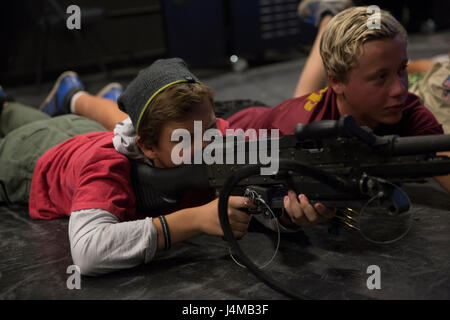 Noah Allen, Boy Scout, Troop 377, fires a M249 Squad Automatic Weapon at the Indoor Simulated Marksmanship Trainer aboard Marine Corps Air Ground Combat Center, Twentynine Palms, Calif., Nov. 5, 2016, during the Boy Scout Camp Out for local Boy Scouts of America troops. (Official Marine Corps photo by Cpl. Medina Ayala-Lo/Released) Stock Photo