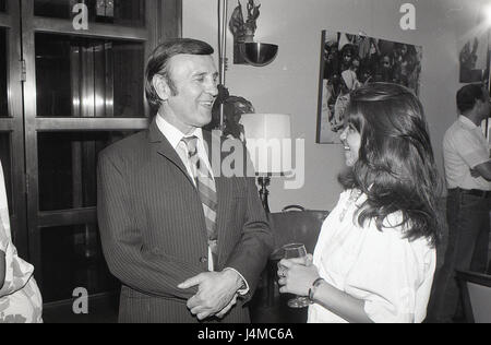 A man and a woman engage in a conversation during a professional or social setting. Stock Photo