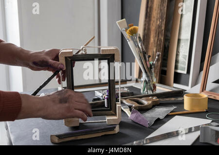 Hands of Caucasian artist making picture frame Stock Photo