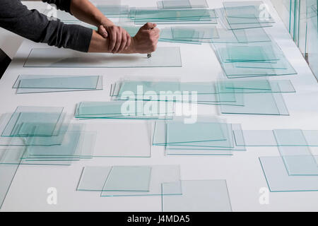 Piles of glass and glass cutter on white table Stock Photo
