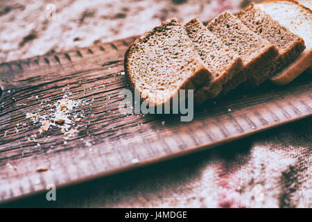 Close up of slices of bread and crumbs on wooden tray Stock Photo