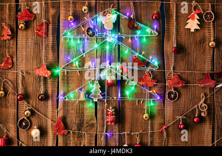 Christmas ornaments hanging on string on wood Stock Photo