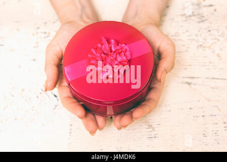 Hands of woman holding round gift box Stock Photo