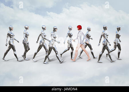 Woman walking in opposite direction of robots Stock Photo