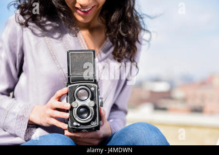 Hispanic woman using vintage camera Stock Photo