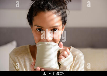 Hispanic woman drinking coffee Stock Photo
