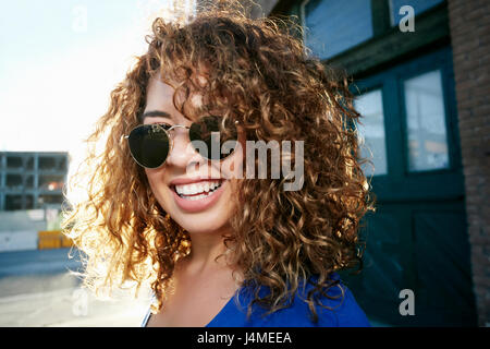 Portrait of smiling Mixed Race woman posing in city Stock Photo
