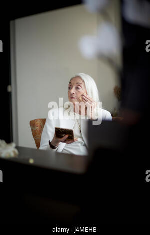 Older Caucasian woman applying makeup Stock Photo