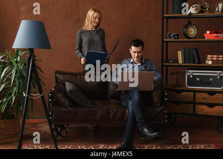 Middle Eastern couple using laptop in livingroom Stock Photo