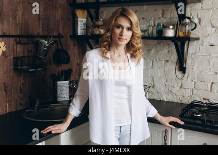 Portrait of serious Middle Eastern woman standing in domestic kitchen Stock Photo