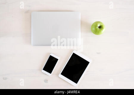 Photographic equipment, Laptop, tablet, telephone, drone, controller and batteries on a desk, ready to travel. Stock Photo