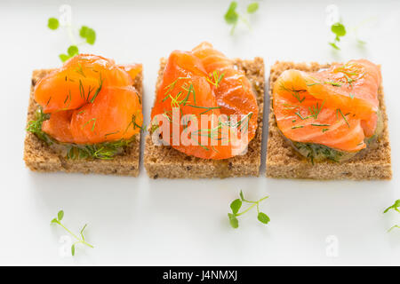 Delicious appetizer canapes of black bread with smoked salmon for holiday Stock Photo