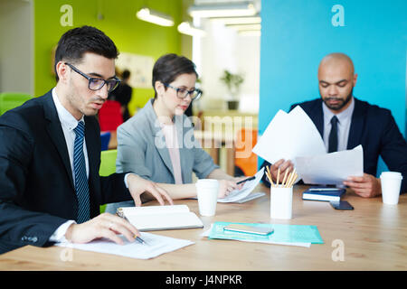 Group of busy managers working with papers in office Stock Photo