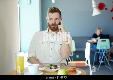 Serious businessman talking to client in cafe Stock Photo