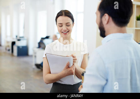 Secretary making notes while talking to employer Stock Photo