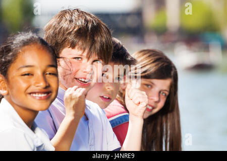 Close-up portrait of happy multiethnic kids, 10-12 years old boys and girls spending holidays outdoors Stock Photo