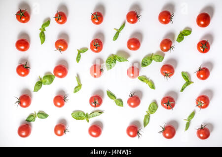 flat lay of beautiful trendy seamless pattern cherry tomato and basil leaves, close up Stock Photo