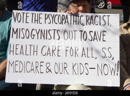 Asheville, North Carolina, USA - February 25, 2017: Older white man holds a sign saying 'Vote the Psychopathic, Racist, Misogynists Out to Save Health Stock Photo