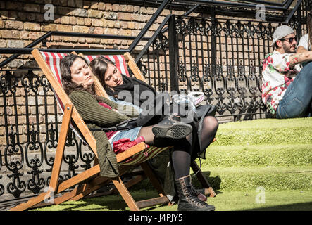 Two women asleep on deckchairs at Camden Market in NW1, London, UK Stock Photo