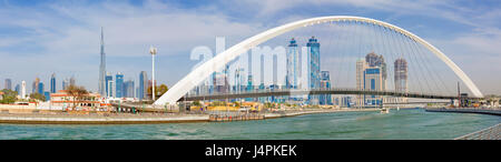 DUBAI, UAE - MARCH 27, 2017: The evening skyline with the arched bridge over the new Canal and Downtown. Stock Photo