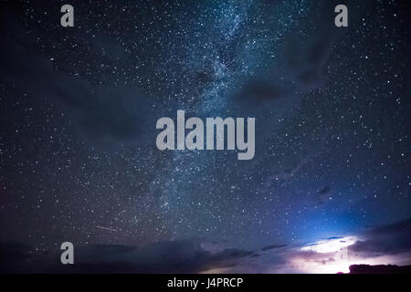 Night sky during thunderstorm in the distance with milky way and stars Stock Photo