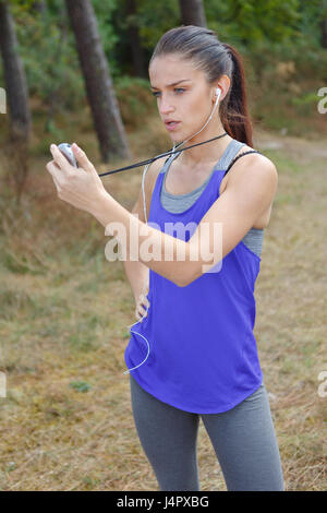 Young female athlete holding stopwatch Stock Photo