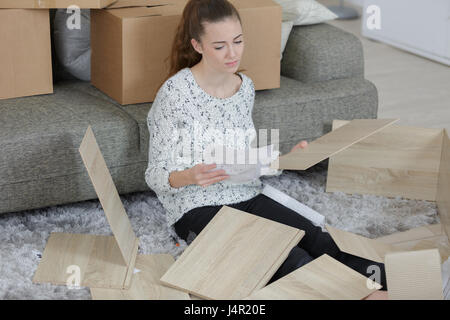 frustrated woman putting together self assembly furniture Stock Photo