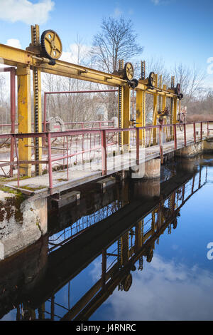 Small dam bridge on the Oredezh River. Leningrad Oblast, Russia. Vertical photo Stock Photo