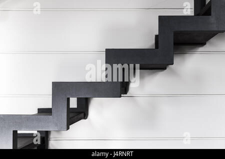 Stairs made of black metal frame and wooden planks goes up, side view. Contemporary interior fragment Stock Photo