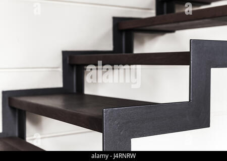 Stairs made of black metal frame and wooden planks goes up. Contemporary interior fragment Stock Photo