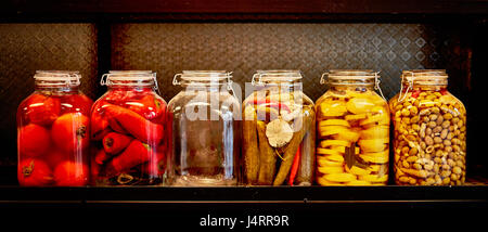 Jars with pickles in a food place, black background