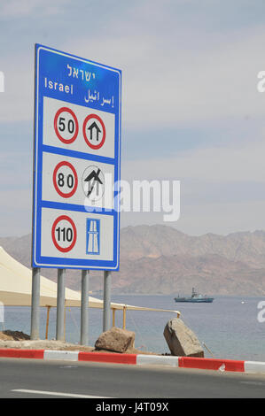 Israeli Speed limits information sign after the Taba border crossing from Egypt into Israel. sraeli navy Dabur class patrol boat in the background Stock Photo