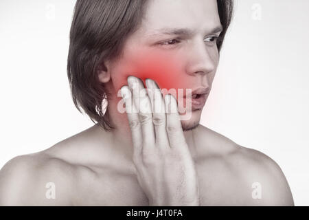 Young man in pain is having a toothache isolated on white background Stock Photo