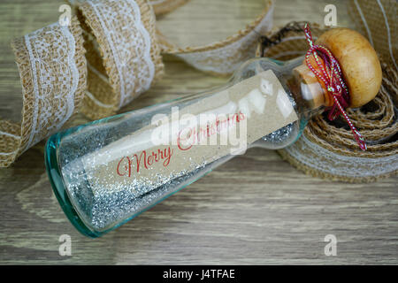 Merry christmas message on brown paper in glass bottle Stock Photo