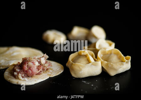 traditional raw manti with meat inside on a black background Stock Photo
