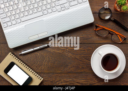 Top view notepaper,pen,cactus,watch,mobile phone,Laptop,coffee on office desk background. Stock Photo