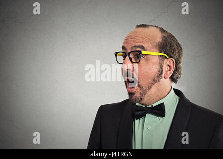 Side profile headshot surprise astonished man. Closeup portrait guy looking surprised in disbelief open mouth isolated grey background with copy space Stock Photo