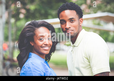 Closeup portrait of a young couple, guy in yellow shirt holding woman with blue shirt, happy moments, positive human emotions on isolated outdoors out Stock Photo