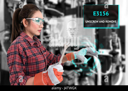 Young female farmer use Ar glasses artificial intelligence adviser to fix industrial machine and holding open end wrench with graphic. Augmented reali Stock Photo