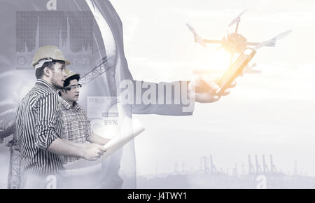 Smart construction , augmented reality in industry 4.0 concept. Double exposure of Business hand suit using mobile phone and two engineers using ar gl Stock Photo