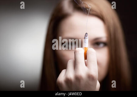 A young woman with a cigarette in his hand. Focus on cigarette Stock Photo