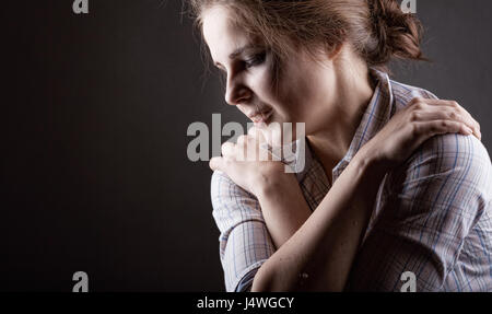Young woman desperately crying on a dark background Stock Photo