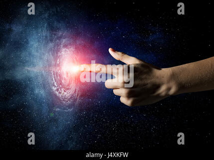 Close up of human hands touching with fingers in space galaxy Stock Photo