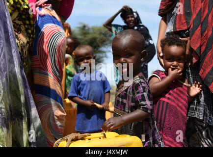 Women and children collect water in the village of Afraaga, Somaliland where charity CARE International have built a storage tank and installed pipelines and taps to give villagers access to clean water from a nearby borehole. Stock Photo