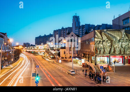 Minsk, Belarus - April 3, 2017: Evening Night Traffic Near Cathedral of Saints Peter and Paul and Bas-relief of the Soviet era on old facade building  Stock Photo