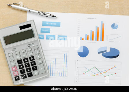 Top view business summary of the year and pen, chart calculator on wood  office desk background. Stock Photo